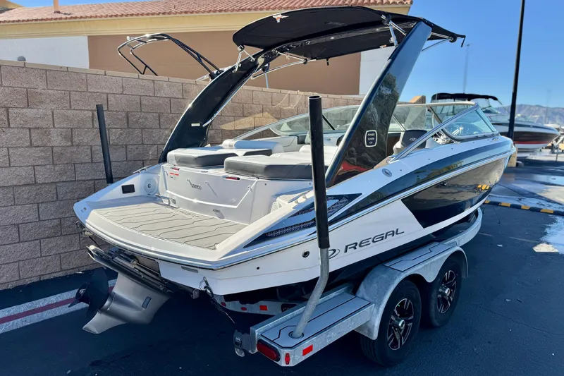 Slide: The Image of 2019 Regal 2100 boat on trailer, parked outdoors, showcasing sleek design and modern features. - 5