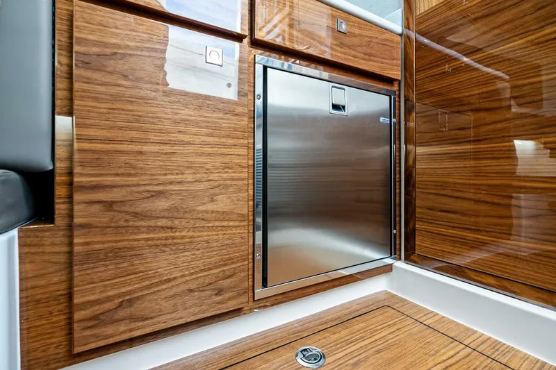 Slide: The Image of 2026 Valhalla Boatworks V-46 interior with sleek wood cabinetry and stainless steel appliance. - 23