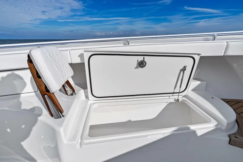 Slide: The Image of 2026 Valhalla Boatworks V-46, open storage compartment, white seating, ocean backdrop. - 34
