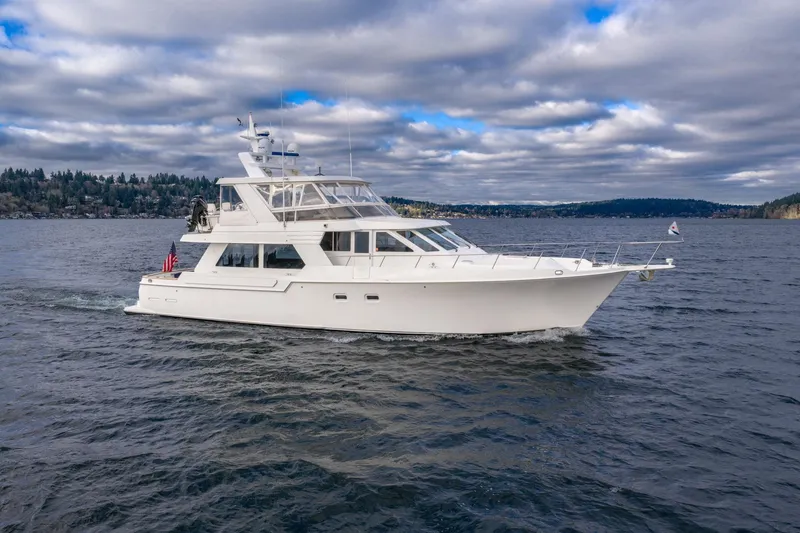 The Image of 1995 Tollycraft 57 Walk Around Pilothouse yacht cruising on a scenic lake under cloudy skies. - 1