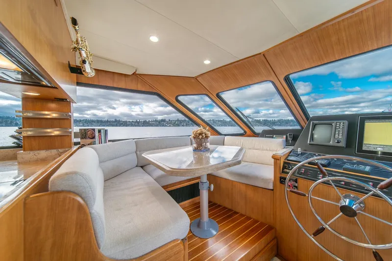 Slide: The Image of Luxurious 1995 Tollycraft 57 Walk Around Pilothouse interior with panoramic windows and elegant seating. - 20