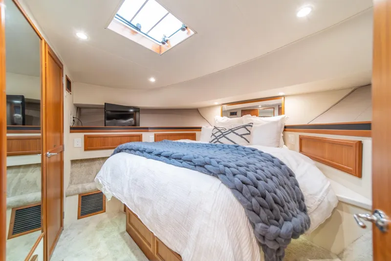 Slide: The Image of Luxurious bedroom in 1995 Tollycraft 57 Walk Around Pilothouse yacht with skylight and cozy bedding. - 32