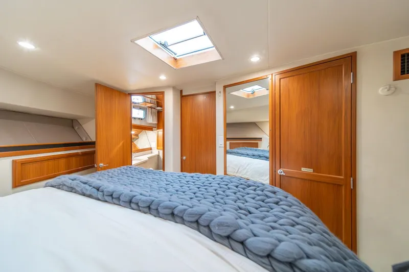 Slide: The Image of Luxurious 1995 Tollycraft 57 Walk Around Pilothouse bedroom with cozy bedding and wooden accents. - 33