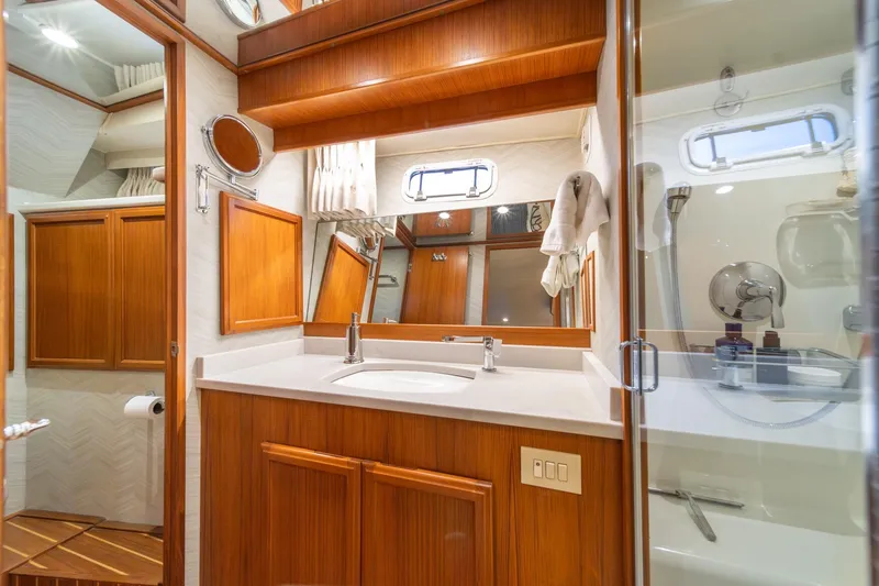 Slide: The Image of Luxurious bathroom in 1995 Tollycraft 57 Walk Around Pilothouse yacht, featuring wood cabinetry and modern fixtures. - 36