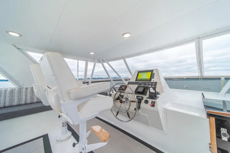 Slide: The Image of 1995 Tollycraft 57 Walk Around Pilothouse helm with modern navigation equipment and comfortable seating. - 44