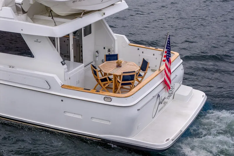 Slide: The Image of 1995 Tollycraft 57 Walk Around Pilothouse yacht with deck seating and American flag. - 48