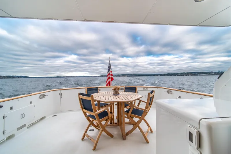 Slide: The Image of 1995 Tollycraft 57 Walk Around Pilothouse yacht deck with table, chairs, and ocean view. - 49