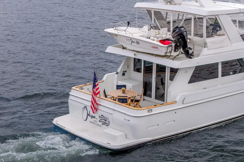 Slide: The Image of 1995 Tollycraft 57 Walk Around Pilothouse yacht cruising on water with American flag displayed. - 50