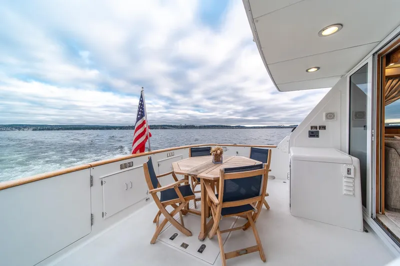 Slide: The Image of 1995 Tollycraft 57 Walk Around Pilothouse yacht deck with seating, American flag, ocean view. - 54