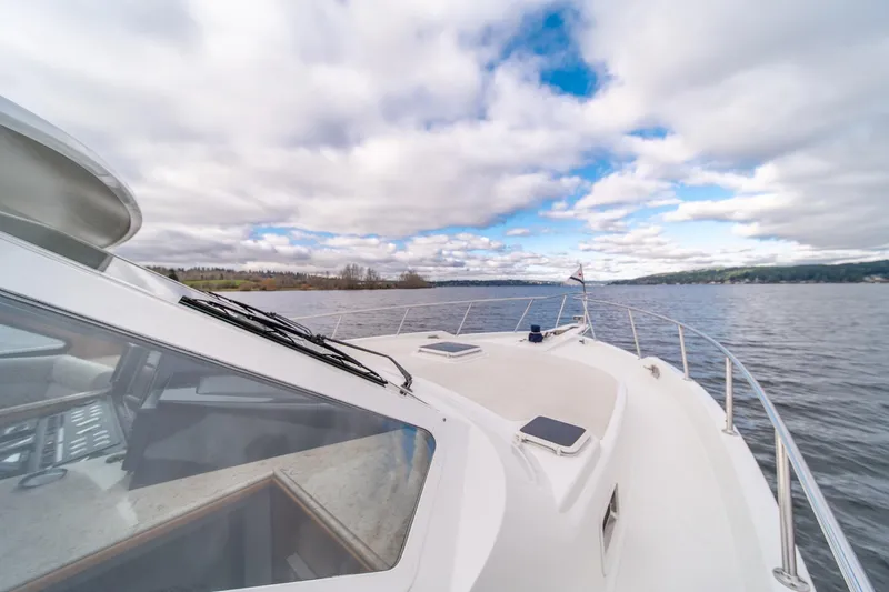 Slide: The Image of 1995 Tollycraft 57 Walk Around Pilothouse on serene water under cloudy sky. - 55