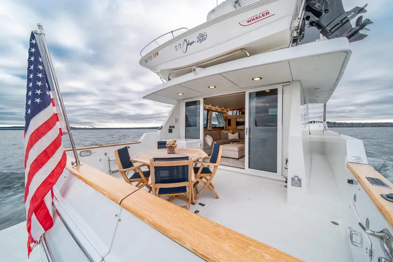 Slide: The Image of 1995 Tollycraft 57 Walk Around Pilothouse yacht with American flag, outdoor seating, and ocean view. - 56