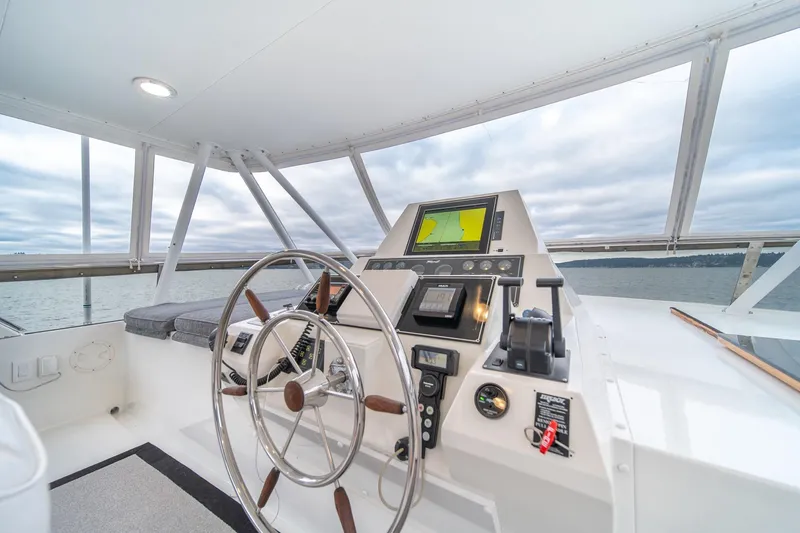 Slide: The Image of 1995 Tollycraft 57 Walk Around Pilothouse helm with steering wheel and navigation equipment. - 57