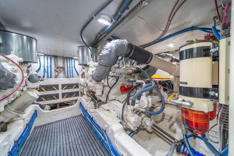 Slide: The Image of Engine room of 1995 Tollycraft 57 Walk Around Pilothouse, showcasing mechanical components and piping. - 65