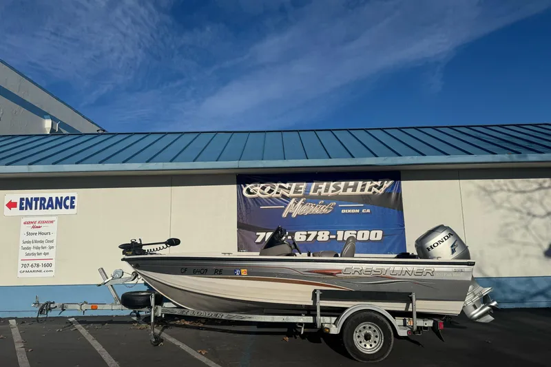 Slide: The Image of 2004 Crestliner 1650 Fish Hawk boat on trailer outside a marine store. - 1