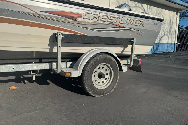 Slide: The Image of 2004 Crestliner 1650 Fish Hawk boat on trailer, parked outdoors. - 2
