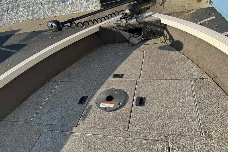 Slide: The Image of 2004 Crestliner 1650 Fish Hawk boat deck with storage compartments and trolling motor. - 9