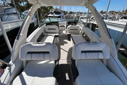 Slide: The Image of 2022 Regal LX6 boat interior with luxurious seating at a marina. - 3