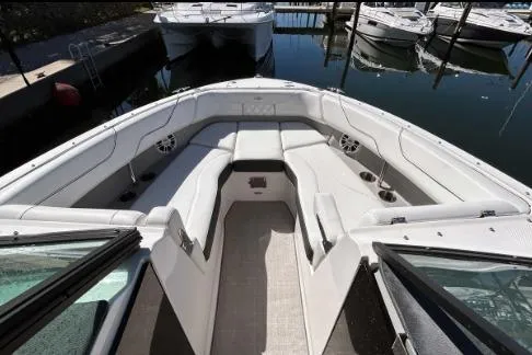 Slide: The Image of 2022 Regal LX6 boat interior with spacious seating, docked in a marina. - 9