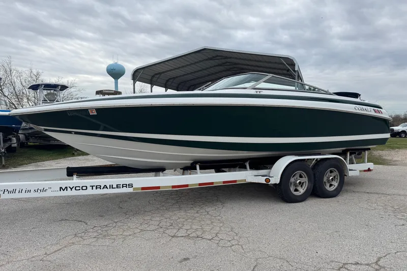 The Image of 1994 Cobalt 252 boat on Myco trailer, parked outdoors under cloudy sky. - 1