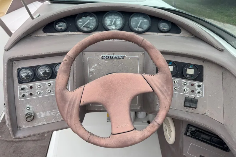 Slide: The Image of 1994 Cobalt 252 boat dashboard with steering wheel and instrument panel. - 16