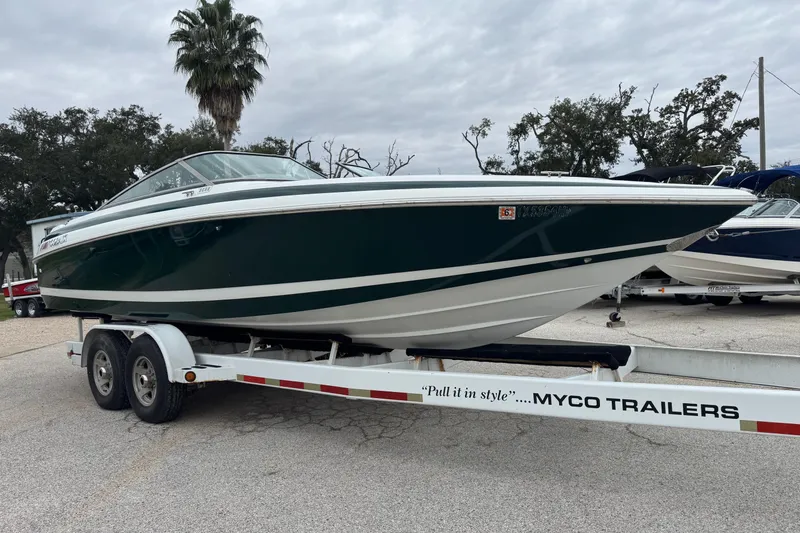 Slide: The Image of 1994 Cobalt 252 boat on Myco trailer, parked outdoors under cloudy sky. - 6