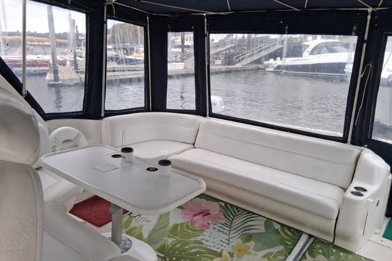 Slide: The Image of Interior of 2000 Sea Ray 460 Sundancer yacht with white seating and marina view. - 10