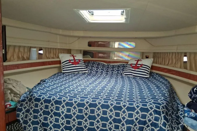 Slide: The Image of Cozy cabin interior of 2000 Sea Ray 460 Sundancer with nautical-themed bedding. - 16