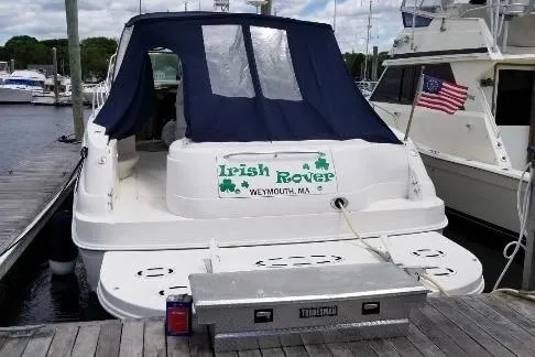 Slide: The Image of 2000 Sea Ray 460 Sundancer docked, featuring "Irish Rover" signage and American flag. - 4