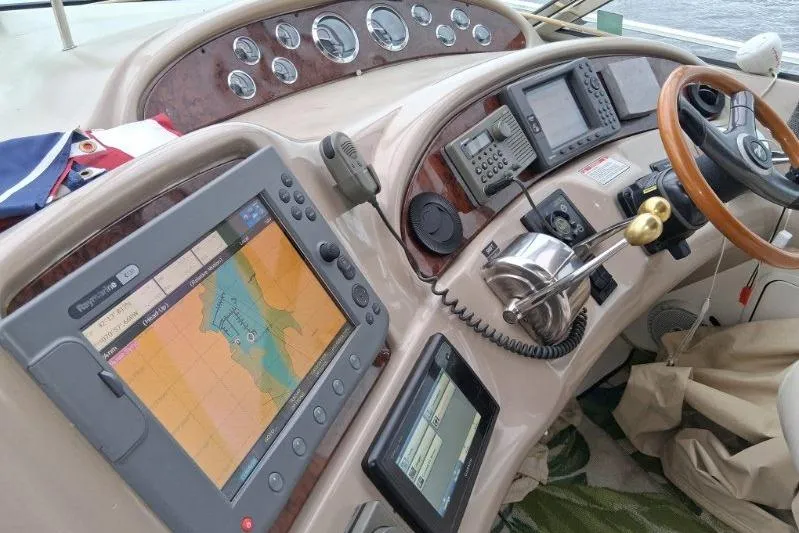 Slide: The Image of Cockpit of 2000 Sea Ray 460 Sundancer with navigation equipment and wooden steering wheel. - 7