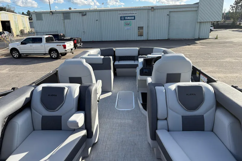 Slide: The Image of 2026 Alera M 23Q boat interior with luxurious seating in a parking lot setting. - 10