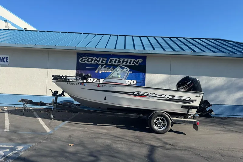 The Image of 2018 Tracker Pro Guide V-165 WT boat on trailer outside fishing store. - 1
