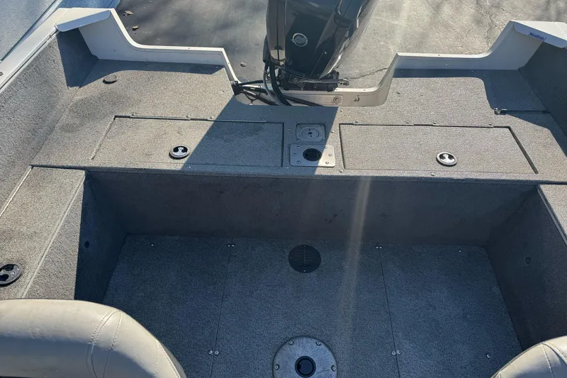 Slide: The Image of 2018 Tracker Pro Guide V-165 WT boat interior with motor, featuring spacious seating and storage. - 17