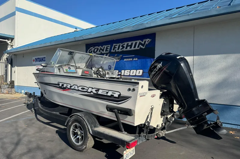 Slide: The Image of 2018 Tracker Pro Guide V-165 WT boat on trailer outside a fishing store. - 7
