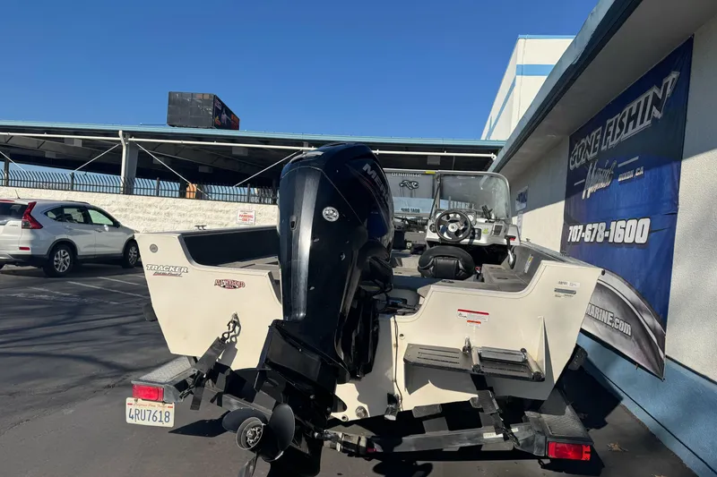 Slide: The Image of 2018 Tracker Pro Guide V-165 WT boat with Mercury outboard motor in parking lot. - 8