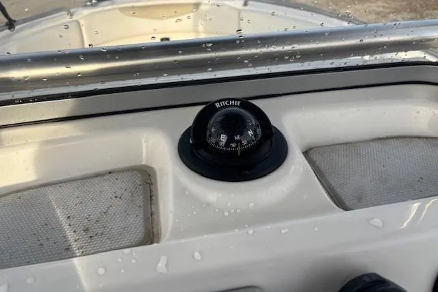 Slide: The Image of 2014 Robalo R222 Center Console with Ritchie compass on dashboard, wet from water droplets. - 16