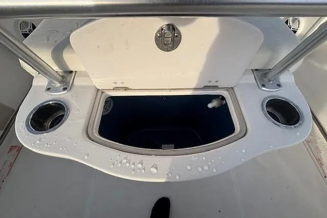 Slide: The Image of 2014 Robalo R222 Center Console with open storage compartment and cup holders. - 28