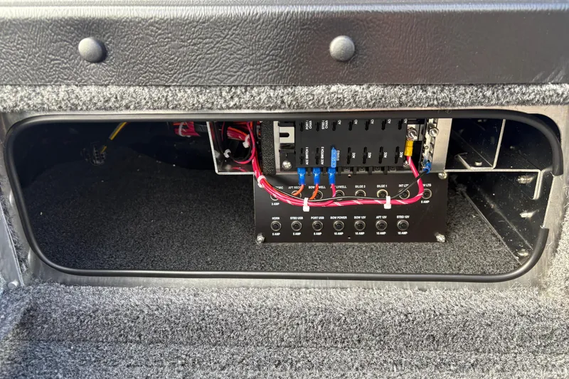 Slide: The Image of Electrical panel inside 2026 Lund 1975 Pro-V Sport boat, featuring wiring and circuit breakers. - 15