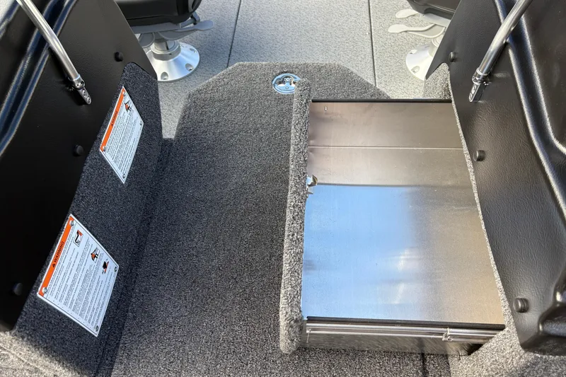 Slide: The Image of Interior of 2026 Lund 1975 Pro-V Sport boat with carpeted flooring and storage compartment. - 16