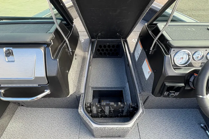 Slide: The Image of 2026 Lund 1975 Pro-V Sport boat interior with open storage compartment and dashboard. - 18