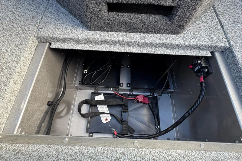 Slide: The Image of Open battery compartment of 2026 Lund 1975 Pro-V Sport boat, showing wiring and storage. - 21