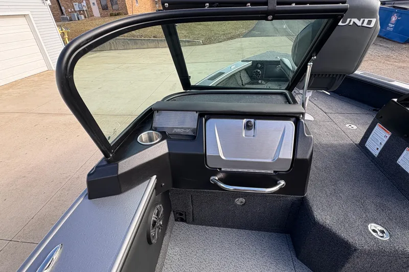 Slide: The Image of 2026 Lund 1975 Pro-V Sport boat interior with windshield and storage compartment. - 22