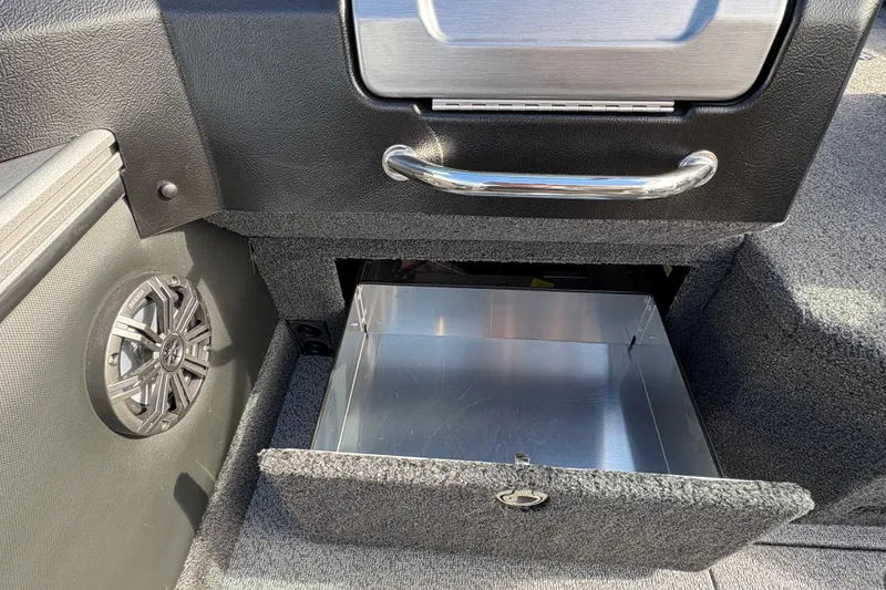 Slide: The Image of Open storage compartment in 2026 Lund 1975 Pro-V Sport boat, featuring speaker and metallic handle. - 33