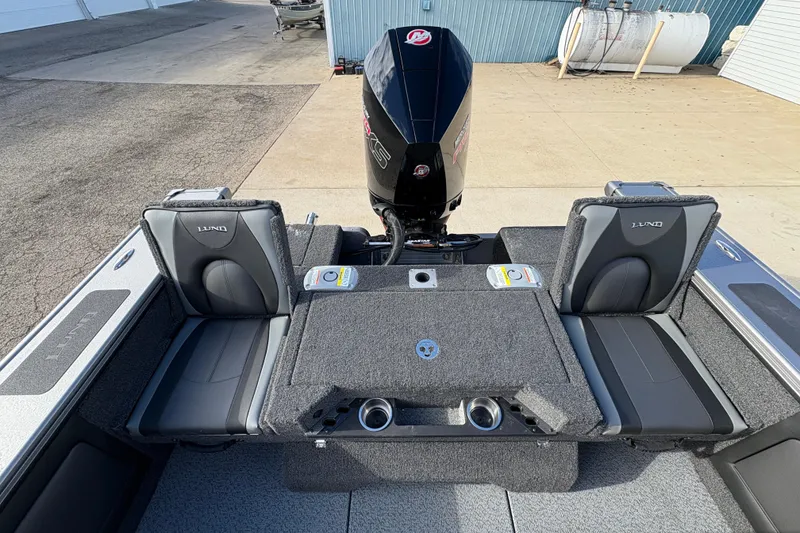 Slide: The Image of 2026 Lund 1975 Pro-V Sport boat interior with seating and motor, docked outdoors. - 38