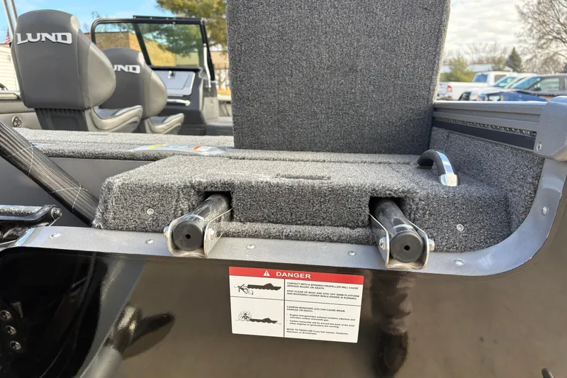 Slide: The Image of 2026 Lund 1975 Pro-V Sport boat interior with seats and safety warning label. - 42