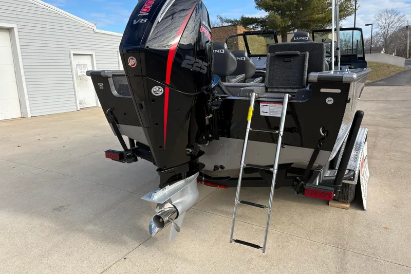 Slide: The Image of 2026 Lund 1975 Pro-V Sport boat with powerful outboard motor and ladder on trailer. - 43