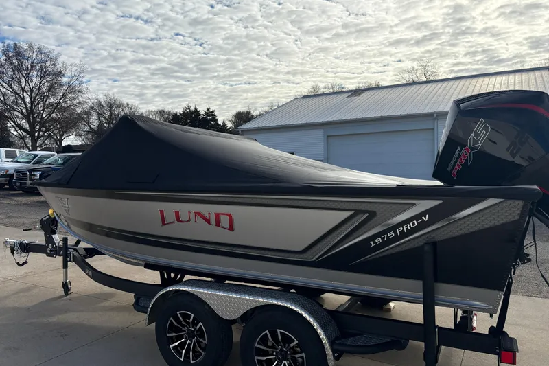 Slide: The Image of Lund 1975 Pro-V Sport 2026 boat on trailer, covered, with Mercury engine. - 44