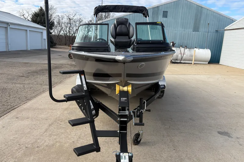 Slide: The Image of 2026 Lund 1975 Pro-V Sport boat on trailer, parked outside industrial building. - 7