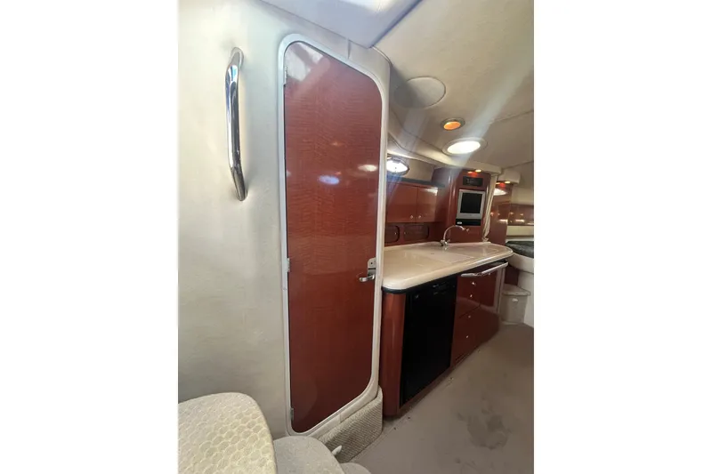 Slide: The Image of Interior of 2004 Sea Ray 340 Sundancer yacht, featuring a compact kitchen area. - 14