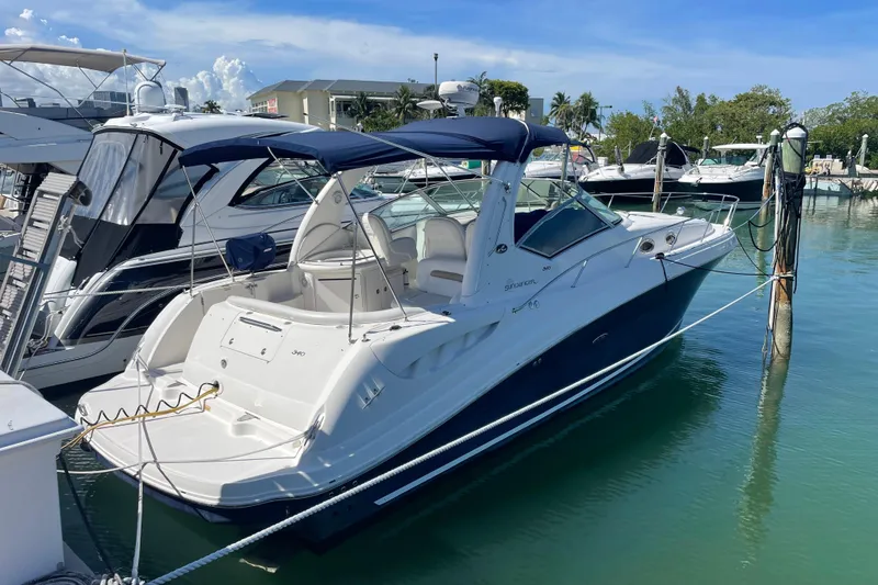 Slide: The Image of 2004 Sea Ray 340 Sundancer docked in a marina under a clear blue sky. - 2