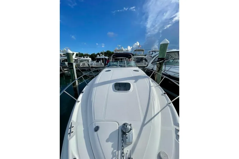Slide: The Image of 2004 Sea Ray 340 Sundancer yacht docked at marina under clear blue sky. - 7